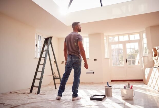 Painter rolling a wall in a bright room