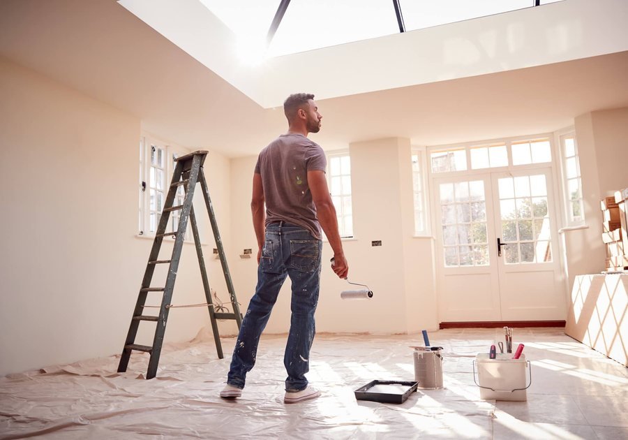 Painter rolling a wall in a bright room