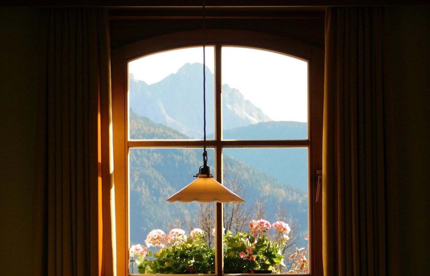 Arched timber window with mountain view