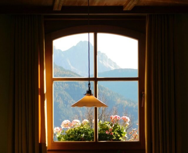 Arched timber window with mountain view